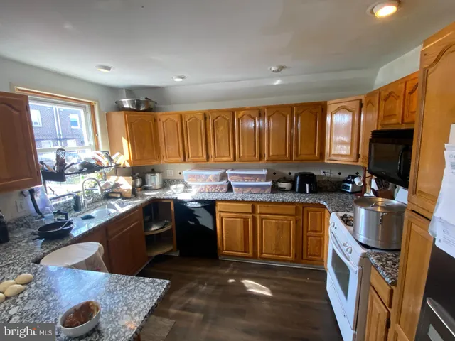 a kitchen with a sink appliances cabinets and a window