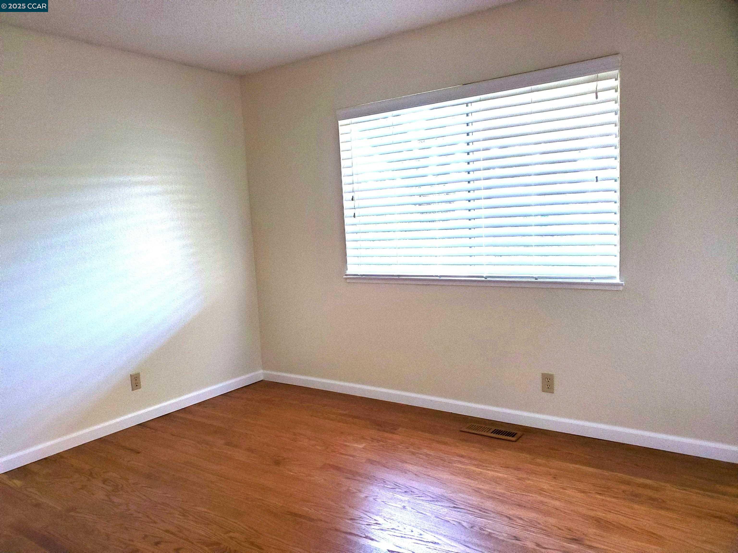1616 Eve Drive Concord, CA 94521 - Photo 17 of 28 an empty room with wooden floor and a window