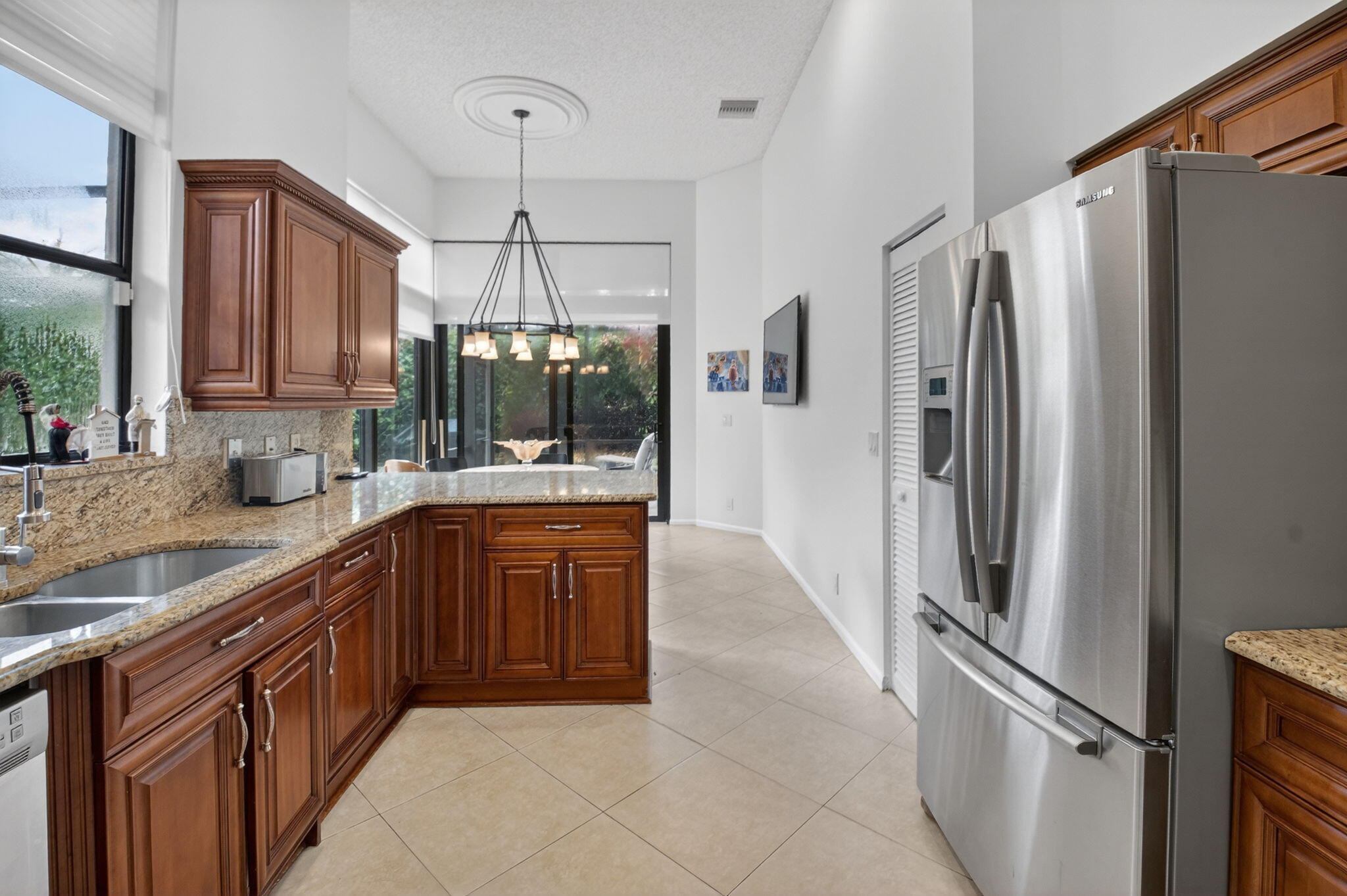 2462 Northwest 63rd Street Boca Raton, FL 33496 - Photo 11 of 41 a kitchen with stainless steel appliances granite countertop a refrigerator and a sink