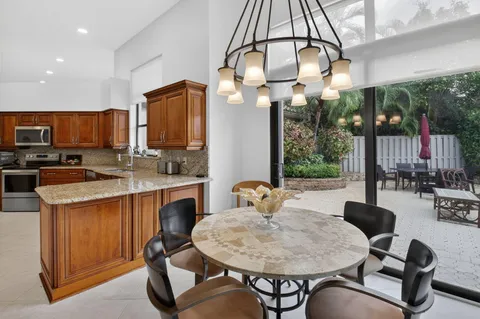 a dining room filled chandelier and kitchen view