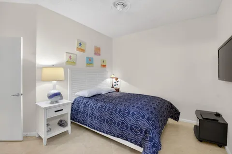 a bedroom with a bed and a lamp on the dresser