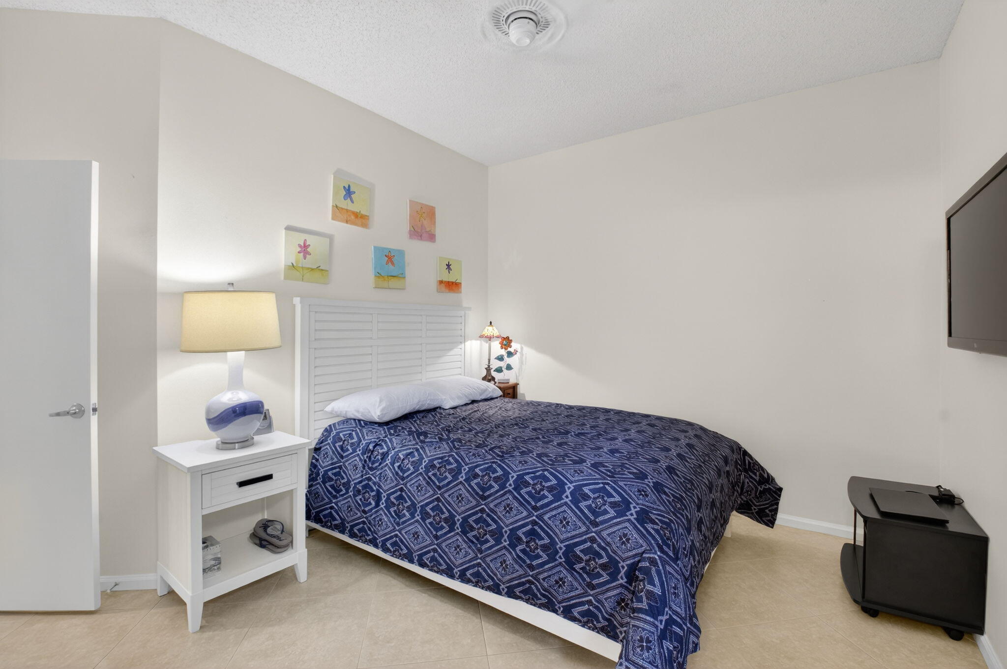 2462 Northwest 63rd Street Boca Raton, FL 33496 - Photo 20 of 41 a bedroom with a bed and a lamp on the dresser