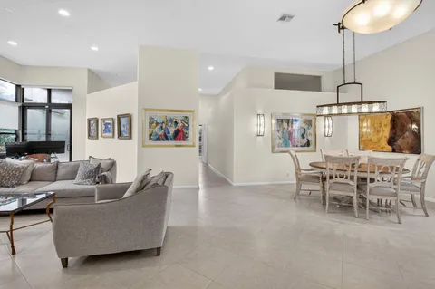 a living room with furniture kitchen view and a chandelier