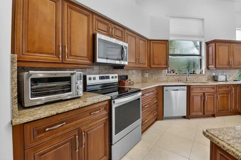 a kitchen with stainless steel appliances granite countertop a stove microwave and cabinets