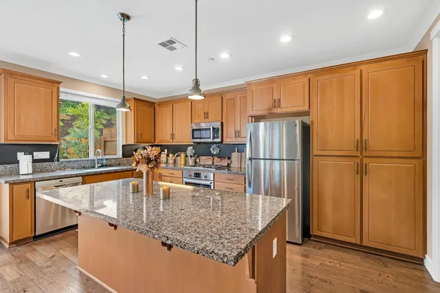 a kitchen with granite countertop sink stove and refrigerator