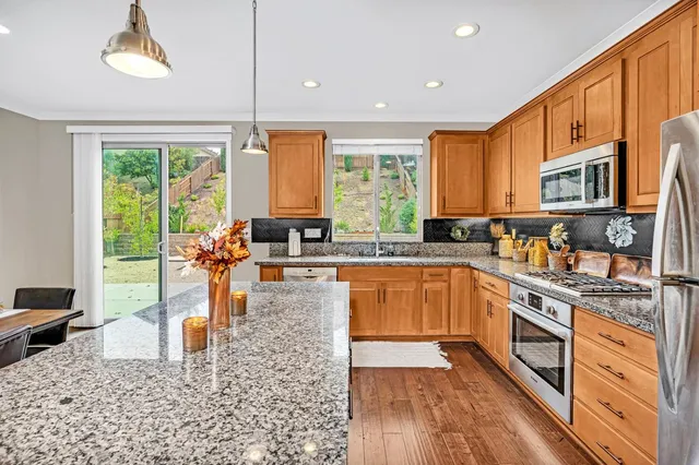 a kitchen with stainless steel appliances granite countertop a refrigerator a sink and dishwasher