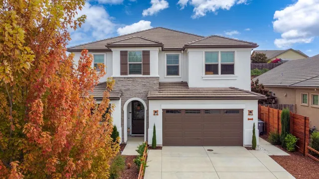 a front view of a house with a yard and potted plants