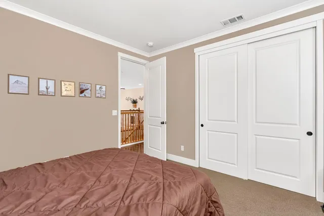 a spacious bedroom with a large bed and a chandelier