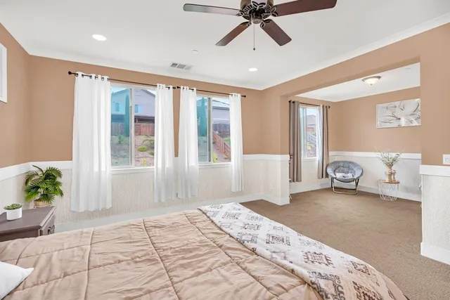 a view of a white house with wooden walls next to a yard
