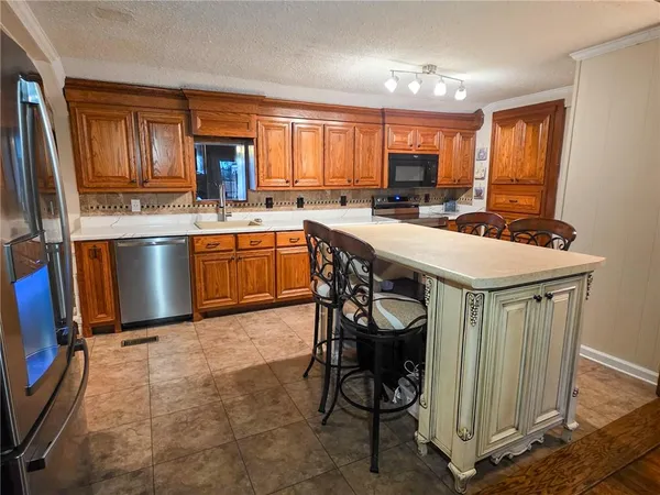a living room with stainless steel appliances furniture and a large window