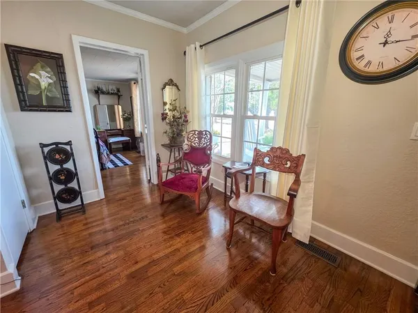 a living room with a bed and paintings on the wall