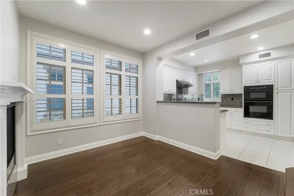 a view of a kitchen with wooden floor and electronic appliances
