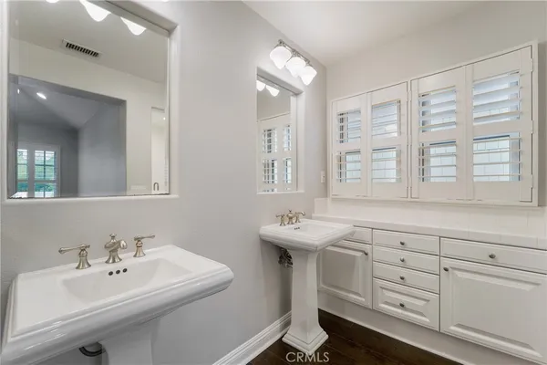 a bathroom with double sink and two mirror