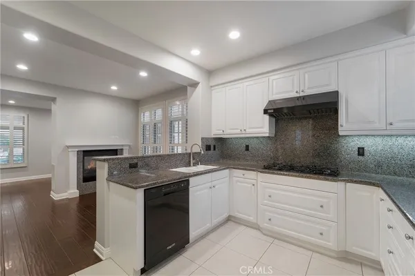 a kitchen with granite countertop white cabinets and white appliances