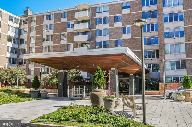 a view of a building with a garden and sitting area