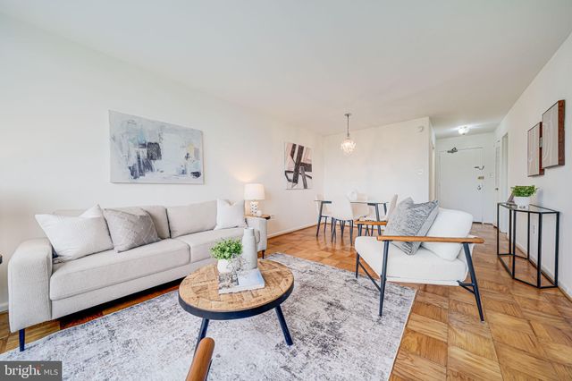 a living room with furniture and a dining table with wooden floor