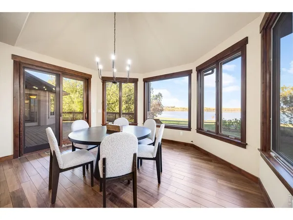 a bedroom with a bed couches and large windows