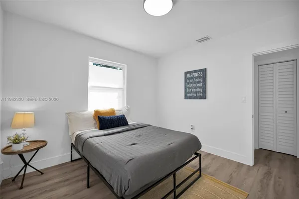 a bedroom with a bed and wooden floor