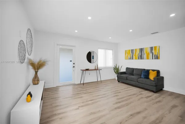 a living room with furniture and a wooden floor