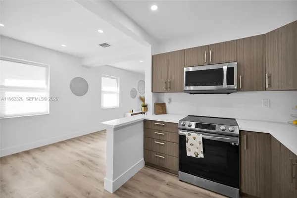 a kitchen with stainless steel appliances a stove microwave and sink