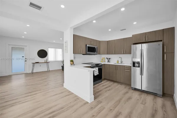 a kitchen with stainless steel appliances a refrigerator sink and microwave
