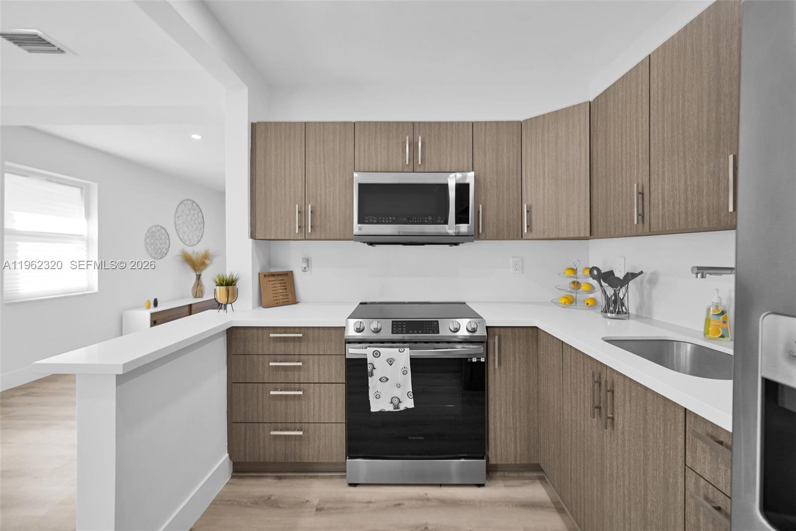 6540 Southwest 4th Street, Unit 6540 Miami, FL 33144 - Photo 21 of 42 a kitchen with stainless steel appliances granite countertop a stove microwave and sink