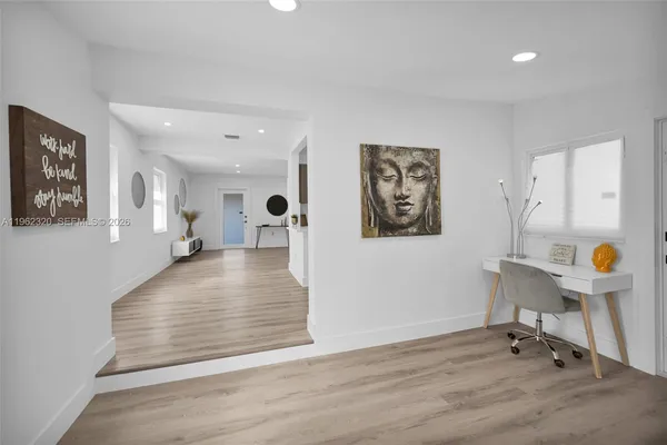 a view of a hallway with wooden floor and furniture