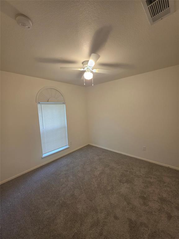1750 Oneal Street Lancaster, TX 75134 - Photo 11 of 14 an empty room with a ceiling fan and a window
