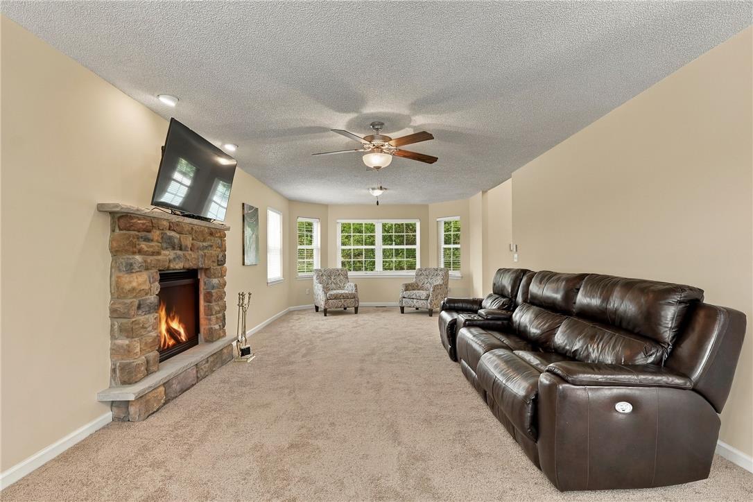 1657 Rachel Road Stroudsburg, PA 18360 - Photo 12 of 46 A stone fireplace anchors this living space detailed with soft carpet and multi-pane windows.