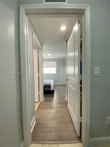 a view of a hallway with a livingroom and a bathroom