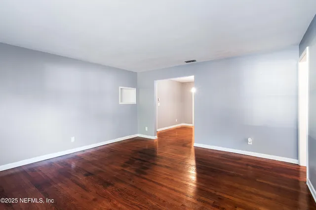 a view of an empty room with wooden floor