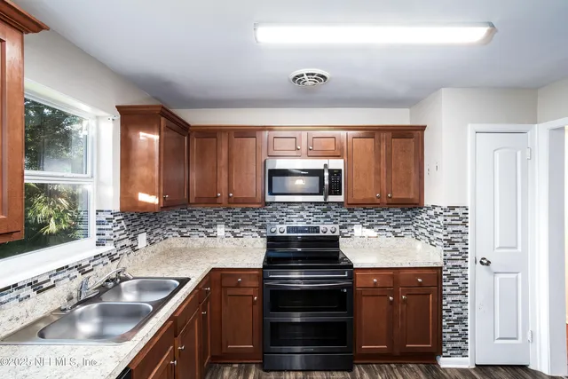 a kitchen with stainless steel appliances granite countertop a sink stove and cabinets