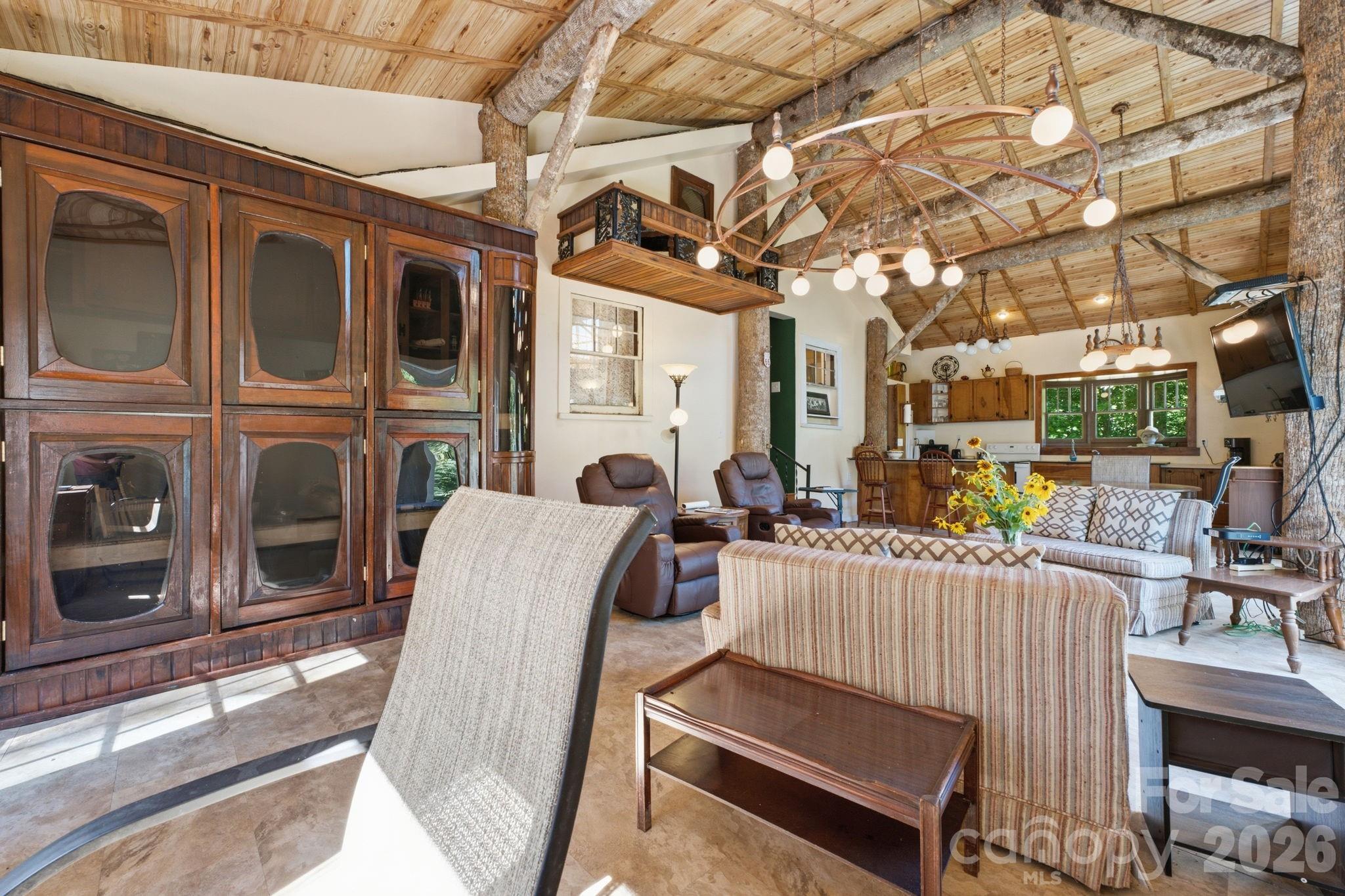 583 Dark Ridge Road Sylva, NC 28779 - Photo 23 of 48 a view of a patio with couches table and chairs with wooden floor