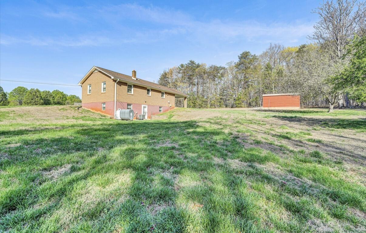 755 Goldmine Road Glade Hill, VA 24092 - Photo 2 of 13 a view of a big house with a big yard and large trees
