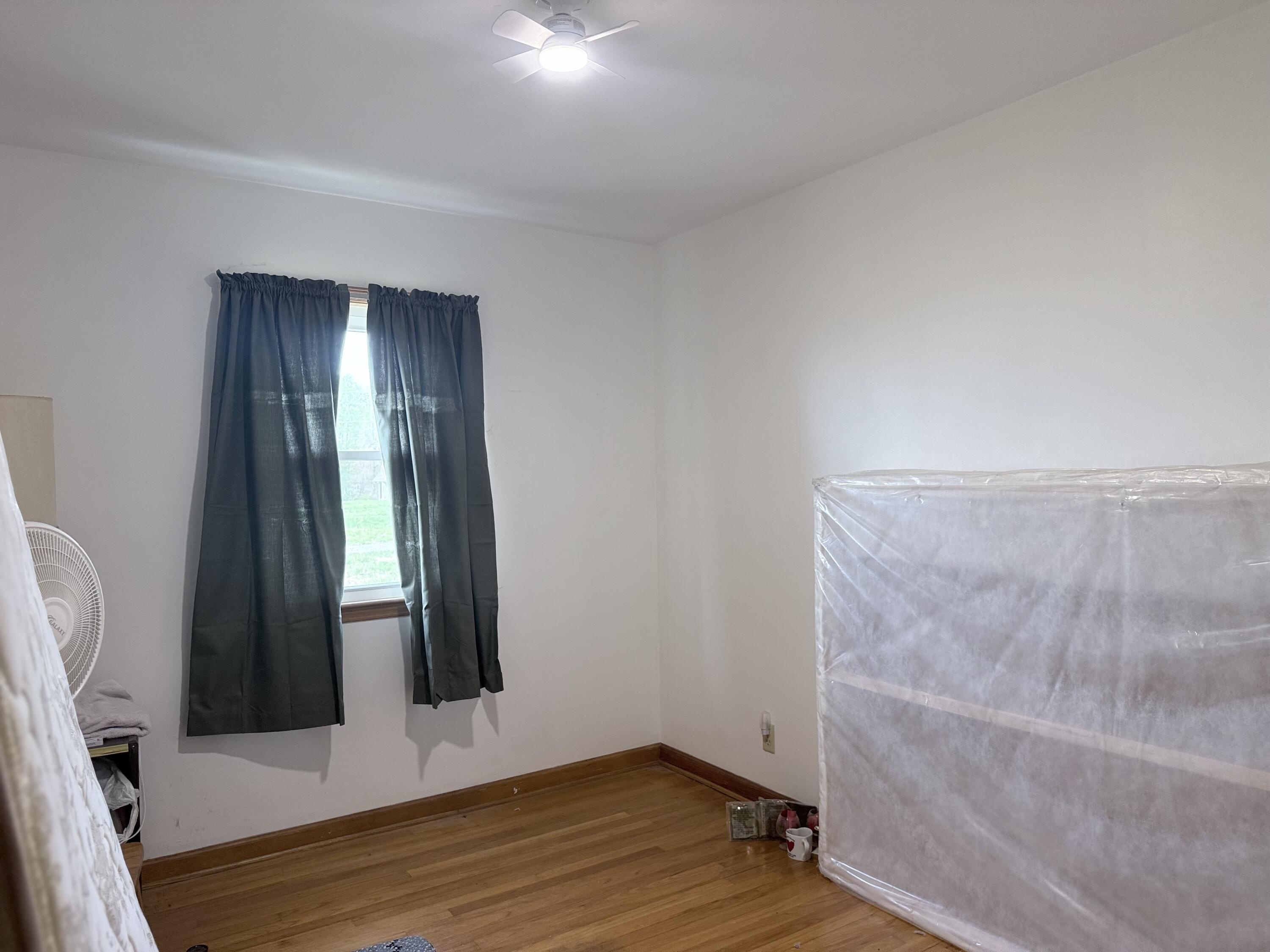 755 Goldmine Road Glade Hill, VA 24092 - Photo 10 of 13 a view of an empty room with wooden floor and a window