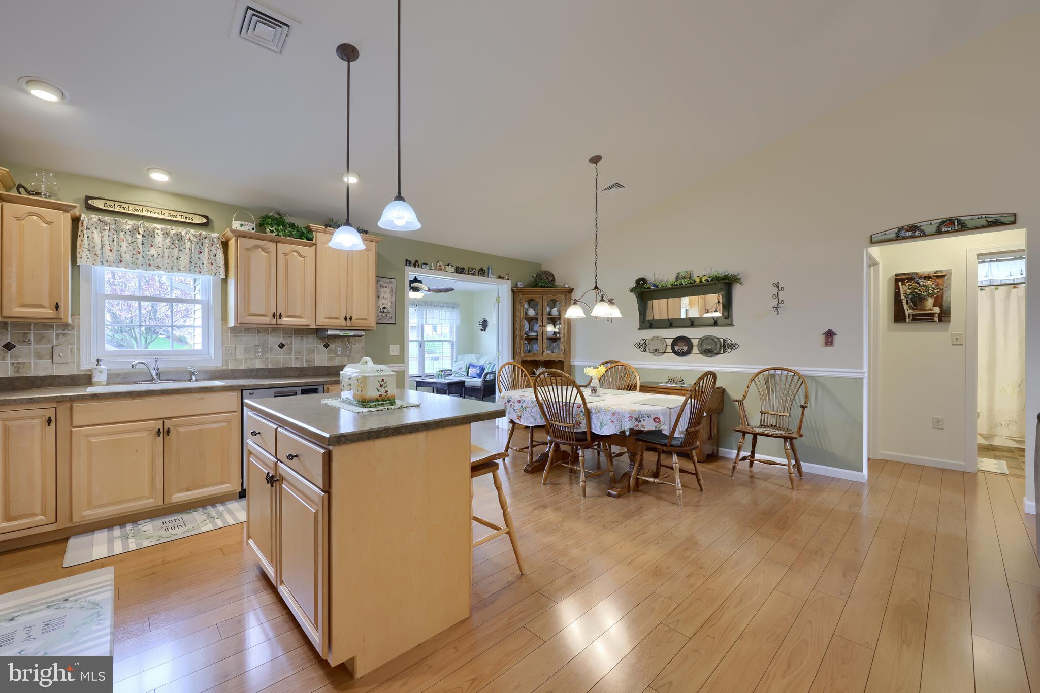 737 Heather Ridge Manheim, PA 17545 - Photo 13 of 40 a open kitchen with stainless steel appliances granite countertop a stove top oven a sink dishwasher a dining table and chairs with wooden floor