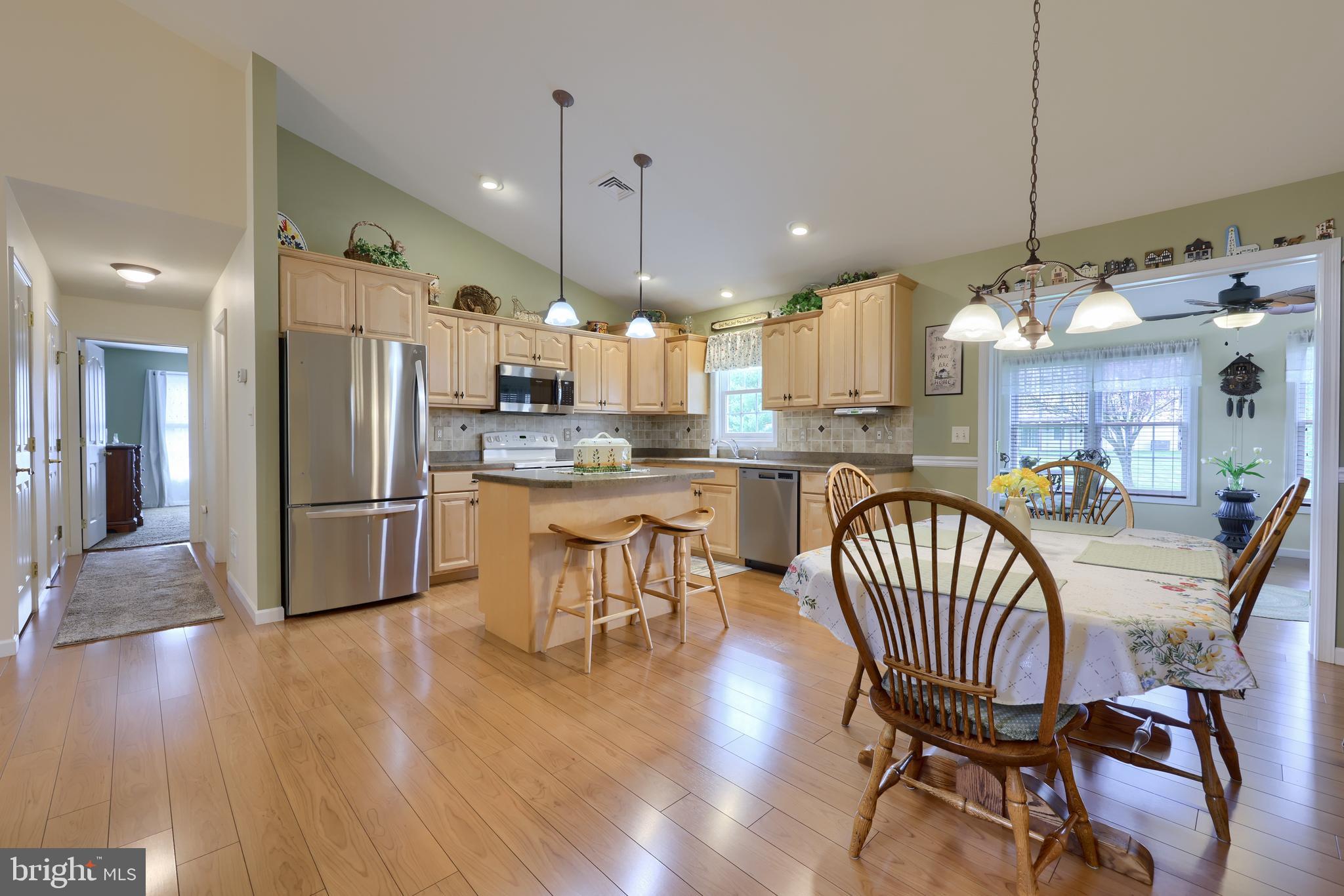 737 Heather Ridge Manheim, PA 17545 - Photo 16 of 40 a kitchen with stainless steel appliances kitchen island granite countertop a dining table chairs and a refrigerator