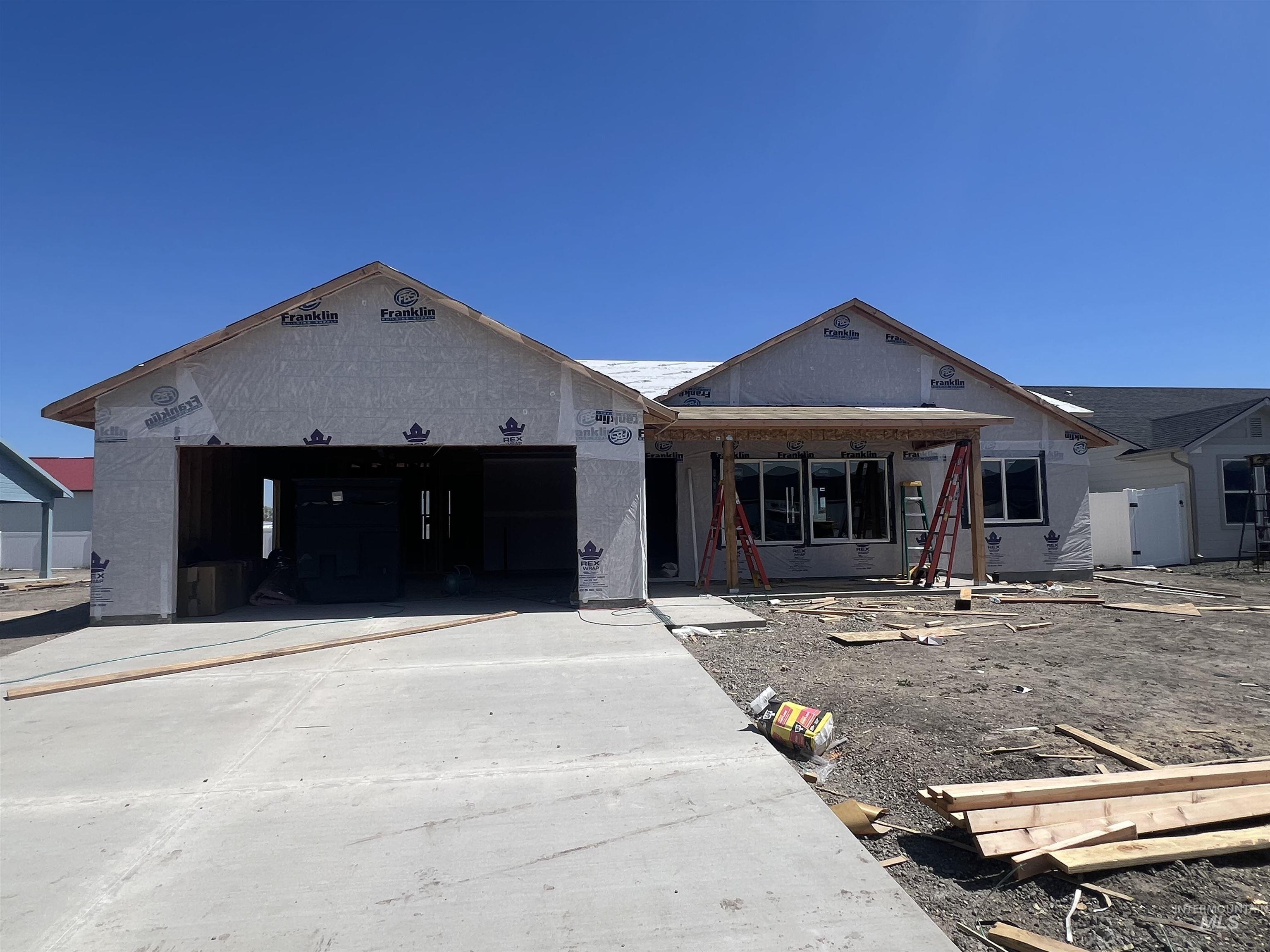 New construction home featuring a concrete driveway, attached two-car garage, and a covered porch entry