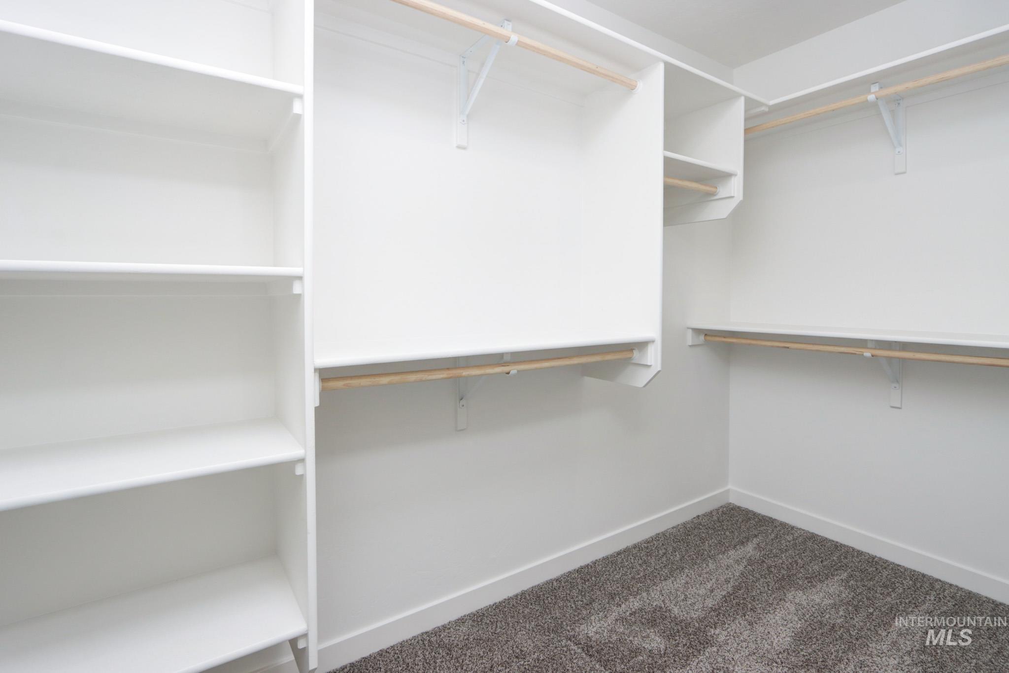 950 Campbell Street Vale, OR 97918 - Photo 18 of 37 Walk-in closet featuring built-in shelving, multiple hanging rods, white walls, white baseboards, and carpet flooring