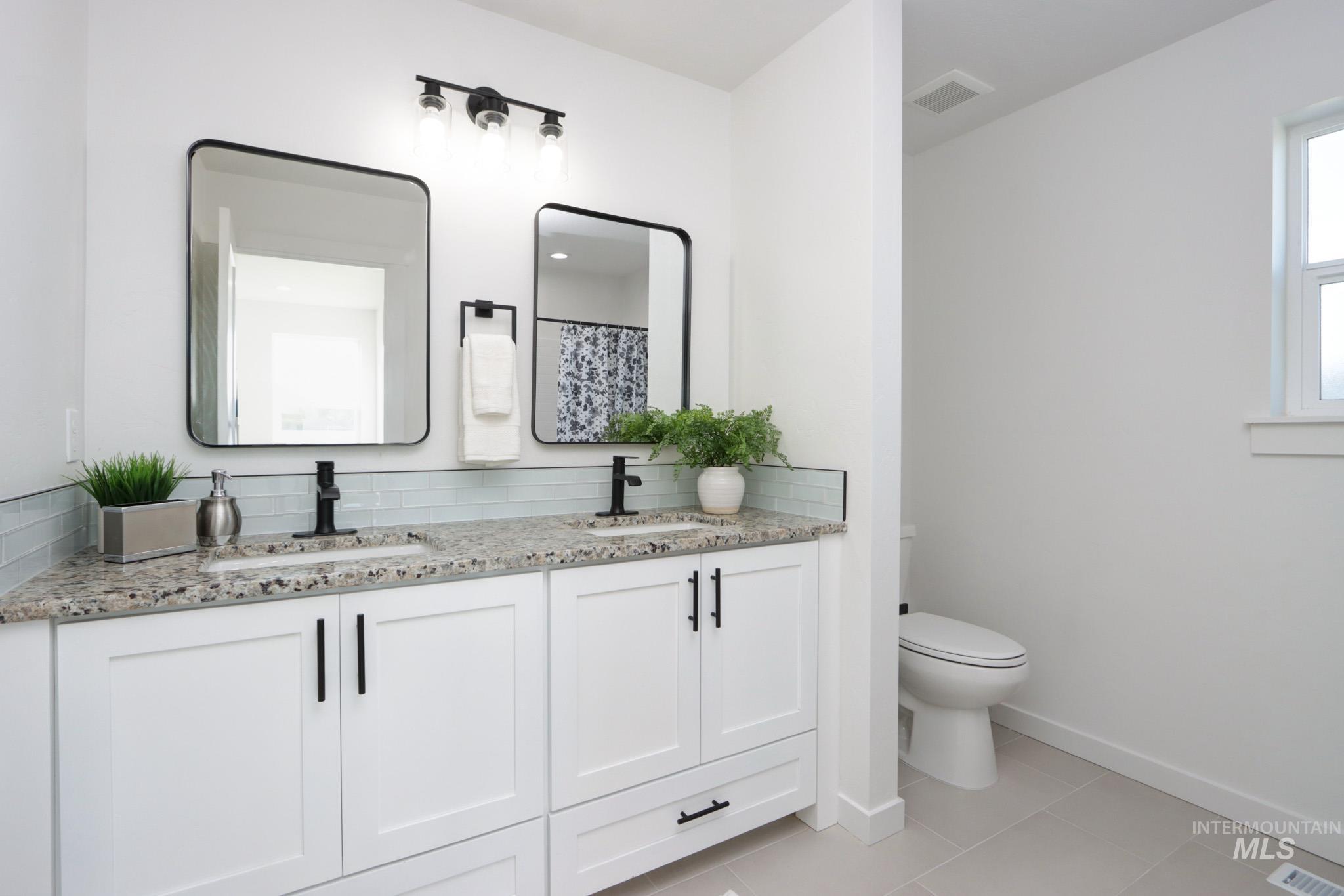 950 Campbell Street Vale, OR 97918 - Photo 20 of 37 Dual vanity with granite-style countertops, white shaker cabinetry, and matte black hardware