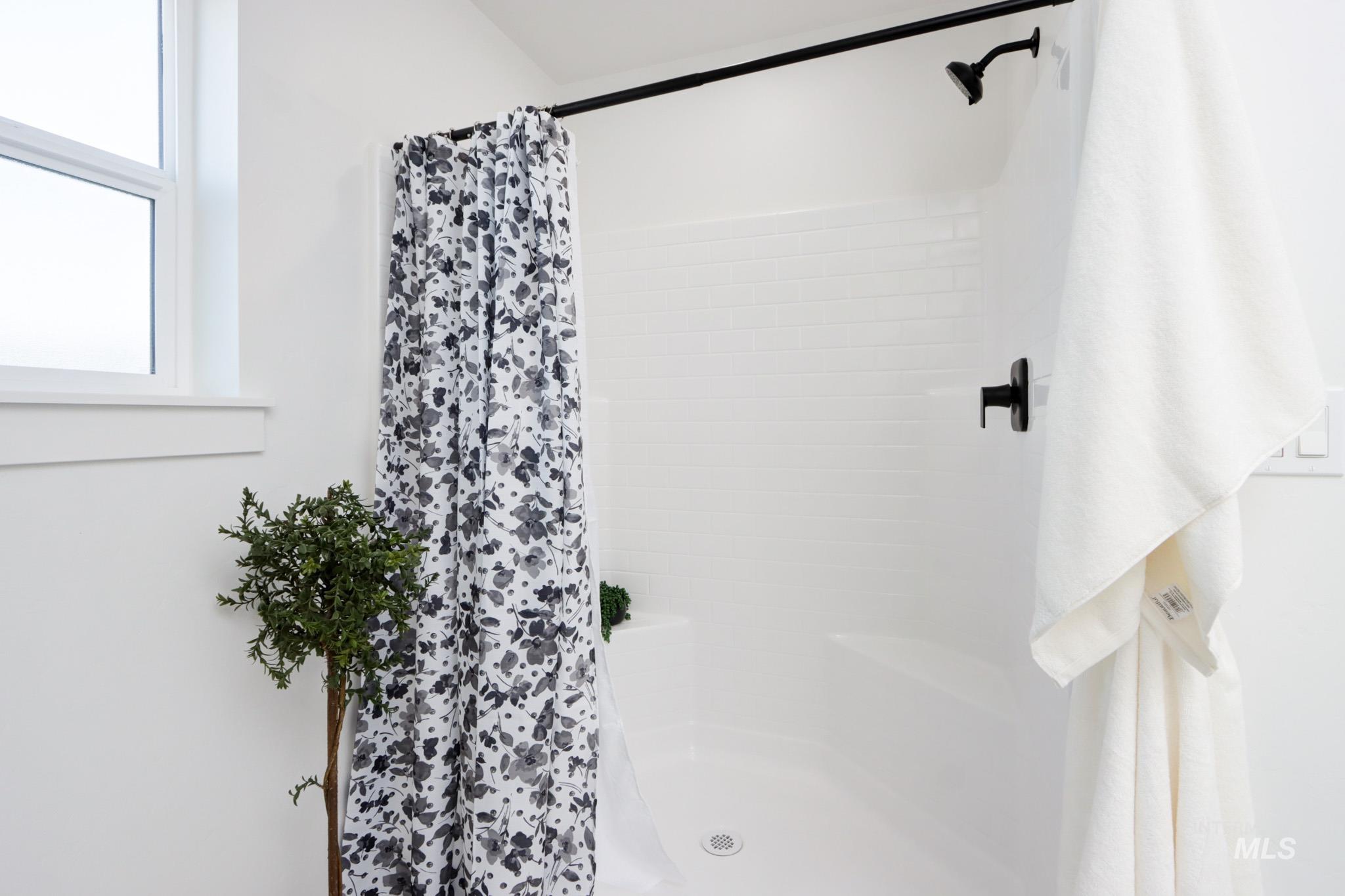 950 Campbell Street Vale, OR 97918 - Photo 21 of 37 Shower featuring white subway tile surround, black plumbing fixtures, and integrated shower bench
