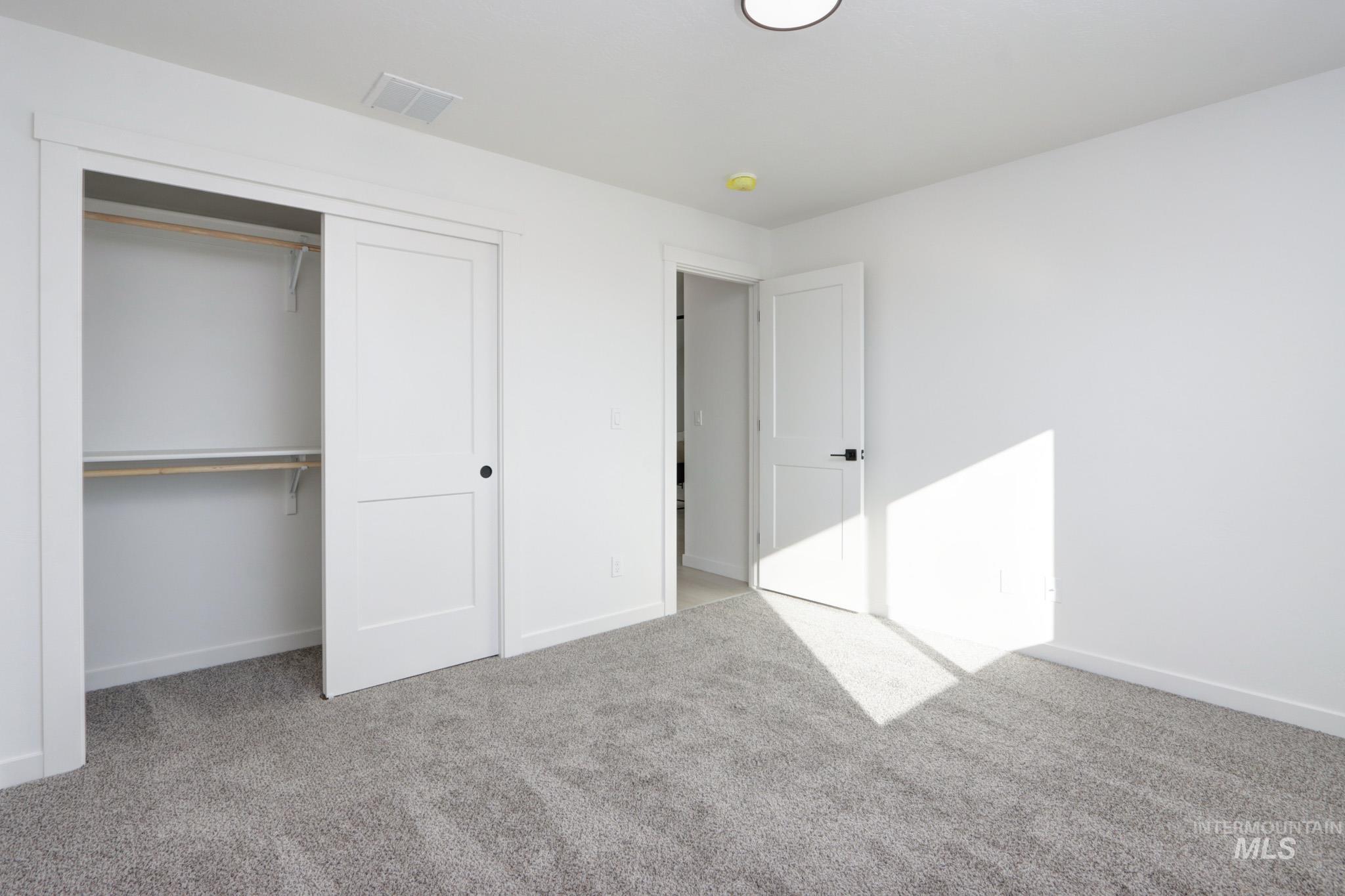 950 Campbell Street Vale, OR 97918 - Photo 26 of 37 Spacious room featuring plush gray carpeting, crisp white walls, a sliding two-panel closet door, and a recessed ceiling light