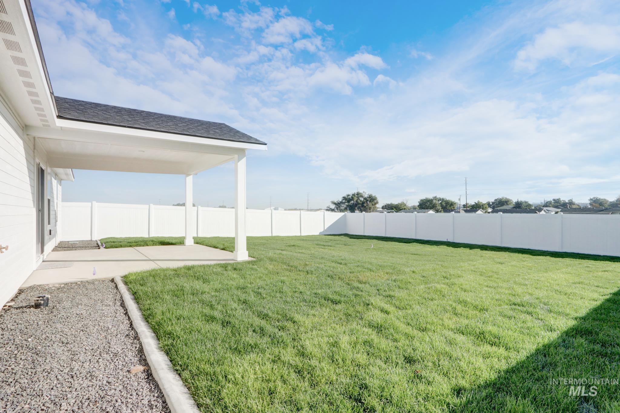 950 Campbell Street Vale, OR 97918 - Photo 32 of 37 Expansive backyard featuring a manicured lawn, a covered patio, and a white privacy fence