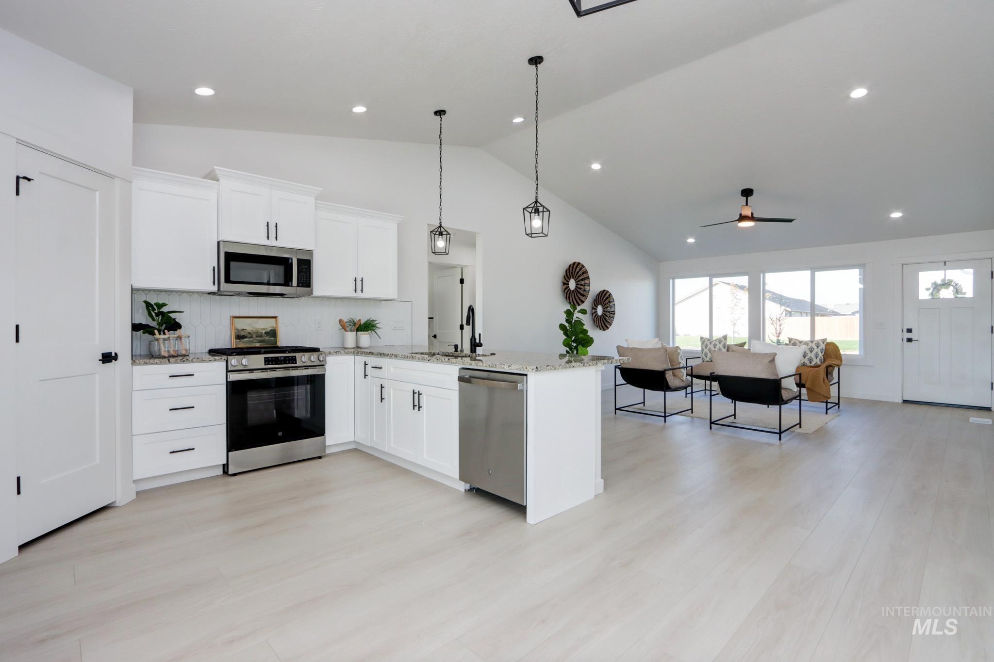 950 Campbell Street Vale, OR 97918 - Photo 4 of 37 Bright open-concept living area featuring a kitchen with white cabinetry, stainless steel appliances, and granite countertops