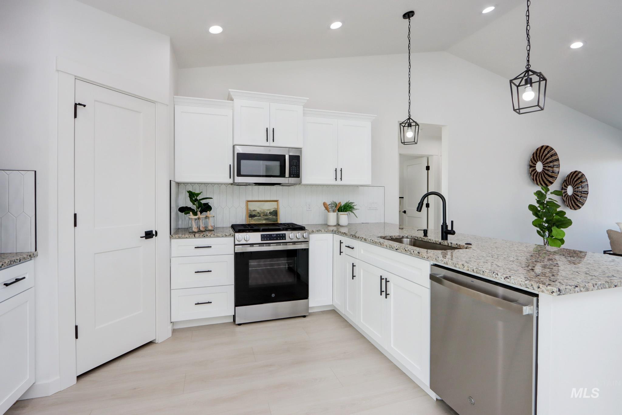 950 Campbell Street Vale, OR 97918 - Photo 5 of 37 Kitchen featuring white cabinetry, light-toned countertops, stainless steel appliances, and wood-finish flooring