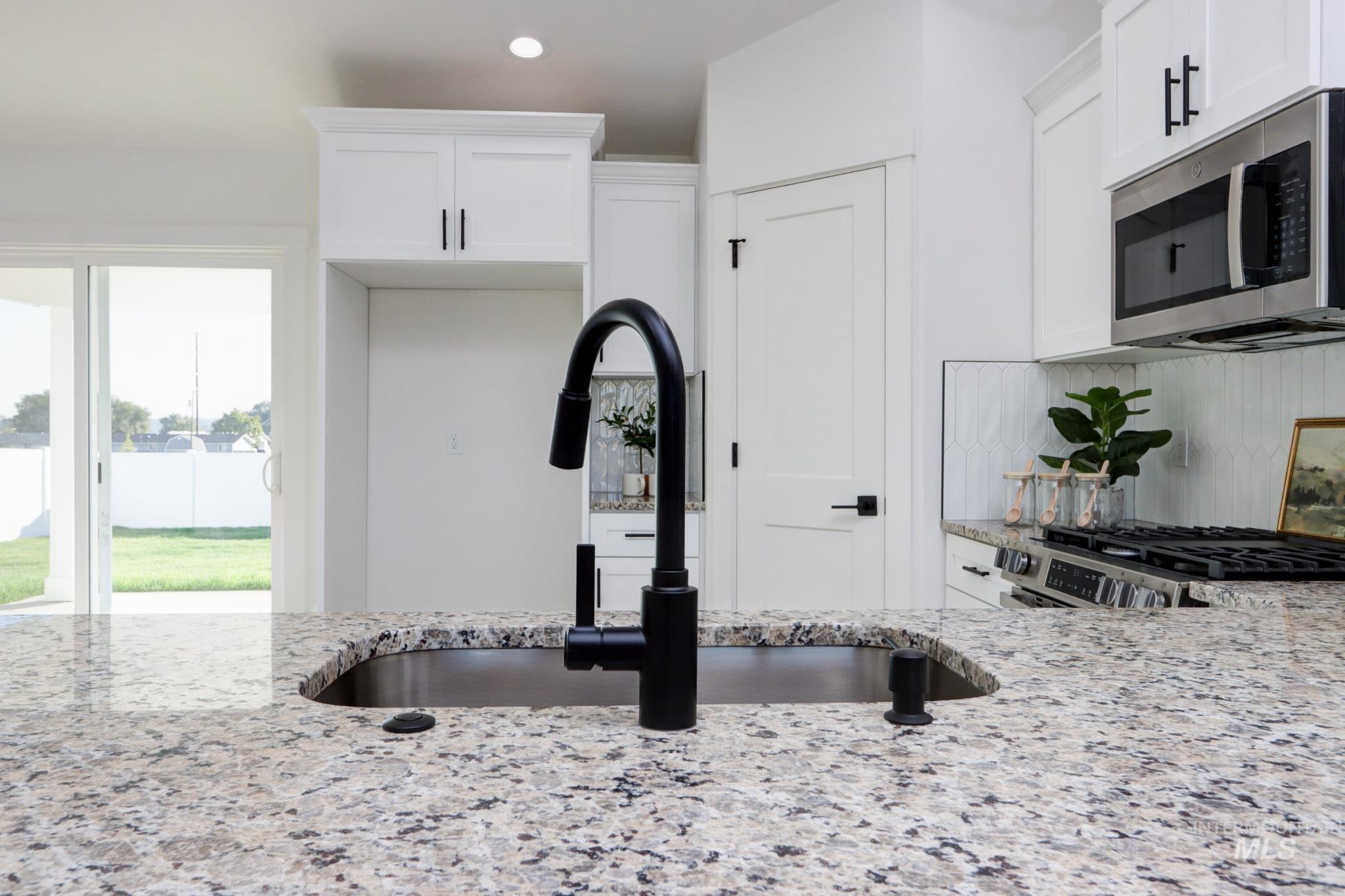 950 Campbell Street Vale, OR 97918 - Photo 9 of 37 Kitchen island with a built-in sink featuring a matte black faucet