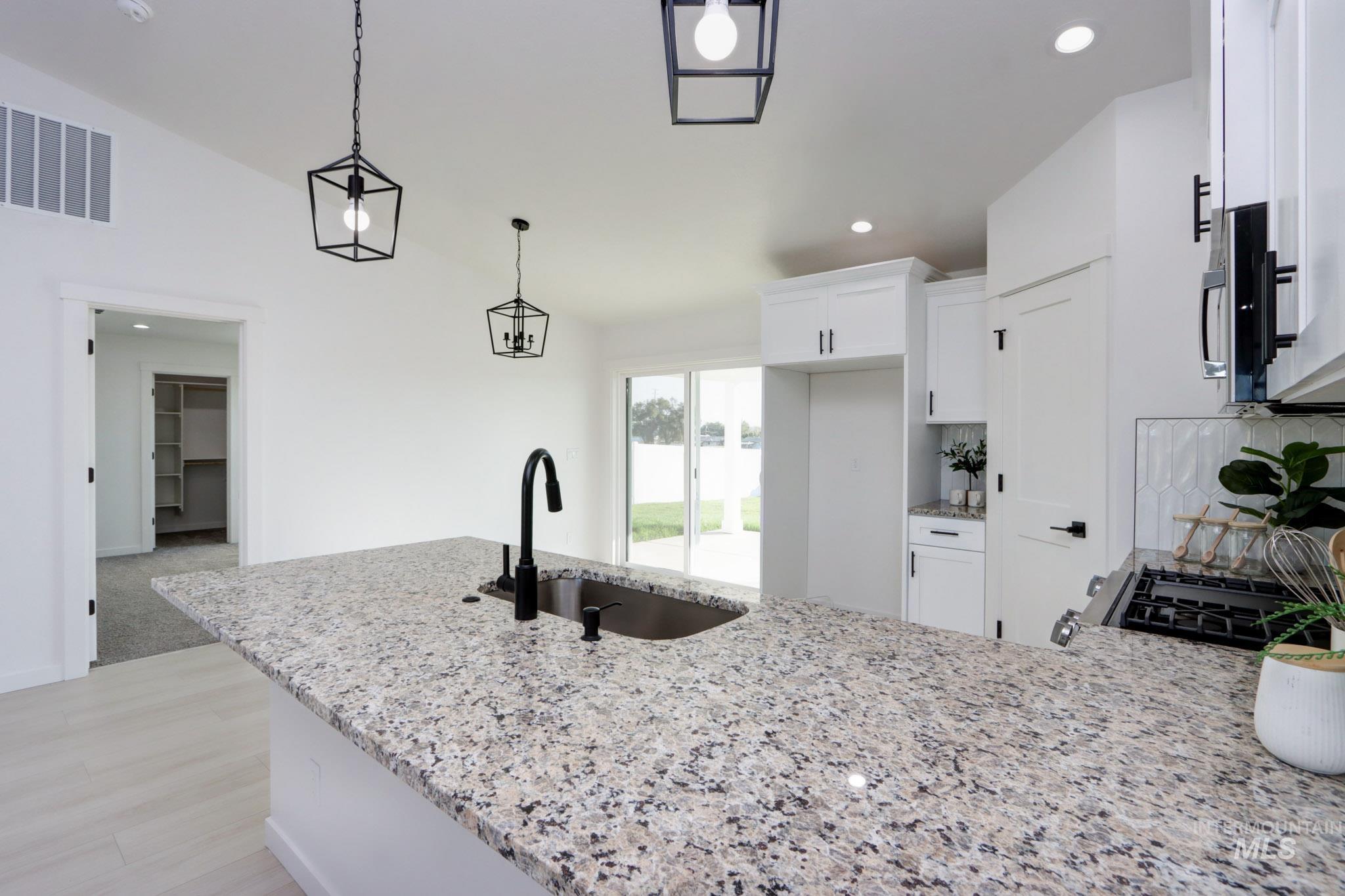950 Campbell Street Vale, OR 97918 - Photo 10 of 37 Kitchen island featuring a stainless steel sink, matte black faucet, and speckled countertop
