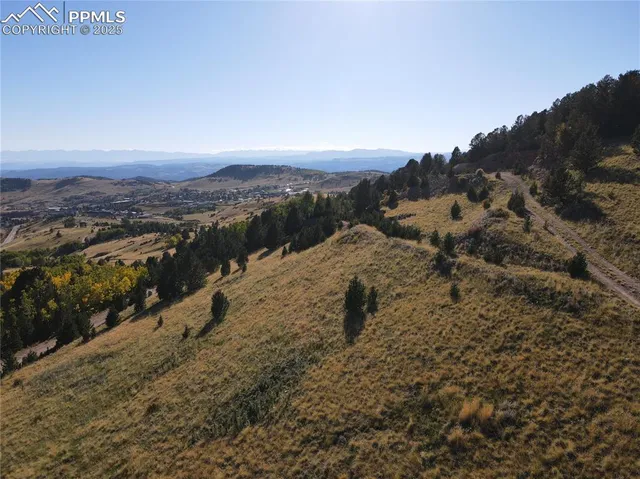 a view of a dry yard with mountains in the background