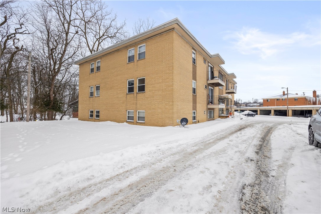 5382 Lee Road, Unit 102 Maple Heights, OH 44137 - Photo 3 of 25 View of snowy exterior featuring brick siding