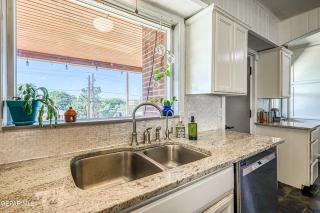 a bedroom with a bed and a potted plant on the dresser